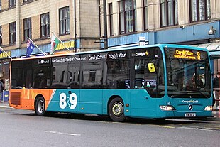 A green-coloured Cardiff Bus bearing the numbers 8 and 9