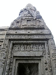 One of the spires with lintel carvings. Carvings on rock at Masroor rock-cut temple.JPG