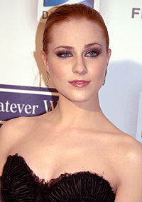 Medium shot of Wood in a black flowy dress, in front of TFF backdrop