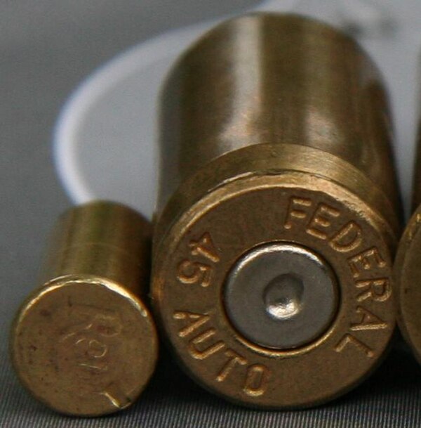 Fired rimfire (left) and centerfire cartridges. A rimfire firing pin produces a notch at the edge of the case; a centerfire pin produces a depression 