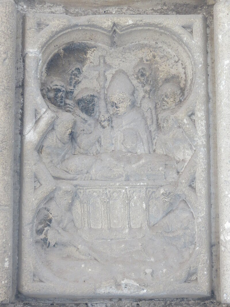 Detalj av den nittende medaljongen på Portail des Marmousets i klosteret Saint-Ouen, som viser Ansbert lede seremonien med skrinleggelsen av Ouen i klosteret, omgitt av munker og en abbed.