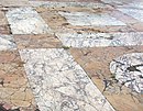 Původní podlaha východní exedry Trajánova fóra s designem kruhů a čtverců ze starověkého žlutého mramoru a mramoru pavonazzetto.
