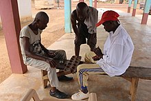Two men playing a board game Men playing oware in Ghana.jpg