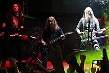 Trois membres d'un groupe de rock jouant devant un public