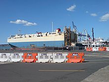 A roll-on/roll-off ship at Captain Cook Wharf, with Queen Mary 2 in the background Ports of Auckland RORO Ship.jpg