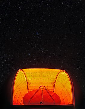 An eerily lit radio telescope observes a starry sky in this image from Kitt Peak National Observatory
