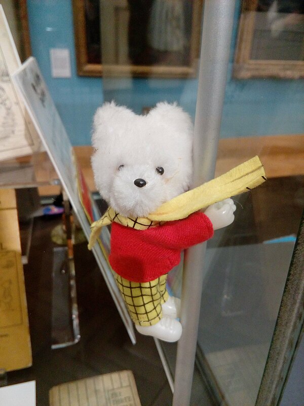 Rupert Bear is recognizable in his red jumper and yellow checked trousers and scarf