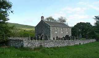 A grey stone church building and graveyard