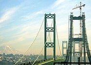 Tacoma Narrows Bridge eastbound span from the Kitsap Peninsula during construction in February 2007, with Tacoma and Mt. Ranier visible in the background.