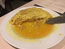 A particularly runny "Betanzos" omelette, popular in Galicia and Madrid. They are normally made without onion, and rely heavily on the careful cooking of the potato. Tortilla de Betanzos La Penela.jpg