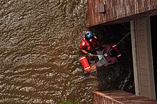 A USCG petty officer pulls a pregnant woman from her flooded New Orleans home. United States Coast Guard Scott D. Rady pulls a pregnant woman from her flooded New Orleans home.jpg