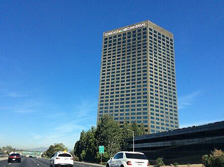 10 Universal City Plaza (in Los Angeles County) in 2015 after Comcast acquired GE's remaining stake in NBC Universal. Notice the wording on the top of the building changed. The Comcast headquarters can be seen at Universal Studios Hollywood.