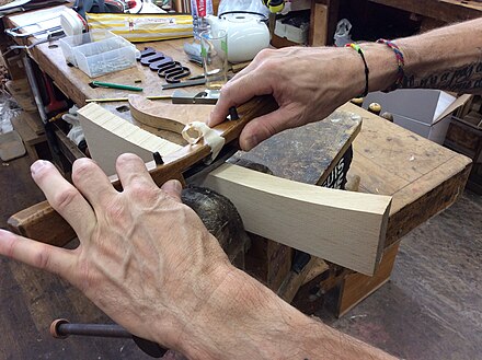 A wooden spokeshave in use