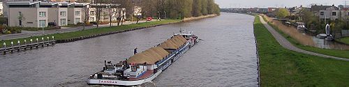 Het motorschip "Bijlmermeer" uit Zaandam vaart over het Van Harinxmakanaal ten zuiden van Leeuwarden.