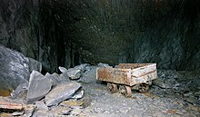 A truck once used for tipping waste stands abandoned in a slate mine near Llangollen following closure. Waste was often dumped into chambers which were no longer in use as it reduced the amount that had to be hauled to the surface. WasteTruck.jpg