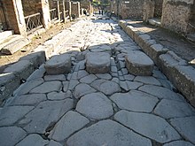 Wheel ruts on an ancient Roman road in Pompeii, designed to guide carriages Wheel ruts Pompeii.JPG