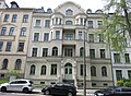 Apartment building in closed development with front garden, fencing and outside staircase