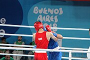 Deutsch: Boxen bei den Olympischen Jugendspielen 2018 Tag 12, 18. Oktober 2018 - Kampf um Bronze im Leichten Weltergewicht Jungen – Hassan Azim (Großbritannien, rot) schlägt Mohammed Boulaouja (Marokko, blau) RSC; Ringrichter ist Wulfren Olivares Peréz (Kolumbien). English: Boxing at the 2018 Summer Youth Olympics on 18 October 2018 – Bronze Medail Match Light Welterweight Boys - Hassan Azim (Great Britain, red) beats Mohammed Boulaouja (Morocco, blue) RSC; Referee is Wulfren Olivares Peréz (Columbia). Español: Boxeo en los Juegos Olímpicos Juveniles de Verano de 2018 en 18 de octubre de 2018 - Medalla de bronce de los hombres ligeros de peso welter: Hassan Azim (Gran Bretaña, rojo) vence a Mohammed Boulaouja (Marruecos, azul) RSC; El árbitro es Wulfren Olivares Peréz (Colombia).