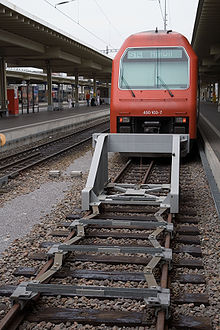 Brake bumper as a welded steel construction with scissor clamping elements screwed onto the rails.