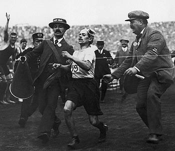 Dorando Pietri is pushed across the finish line by doctors and judges