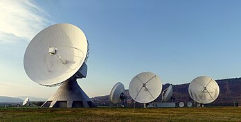Champ d’antennes no 2 de la station terrestre de Fuchsstadt, en Allemagne. Cette station terrestre fait partie du plus important système de communication par satellite, celui de la compagnie américaine Intelsat. Le champ d’antennes no 2 comporte une antenne de 32 mètres, construite en 1985, quatre antennes de 16,4 mètres et de nombreuses autres, plus petites. (définition réelle 2 800 × 1 426)