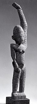 Black and white picture of a female figure with raised arm; 15th–17th century; wood (ficus, moraceae), sacrificial materials; height: 44.8 cm (175⁄8 in.); by the Tellem people; Metropolitan Museum of Art (New York City)