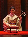 Seorang wanita Jepang memainkan Shamisen.