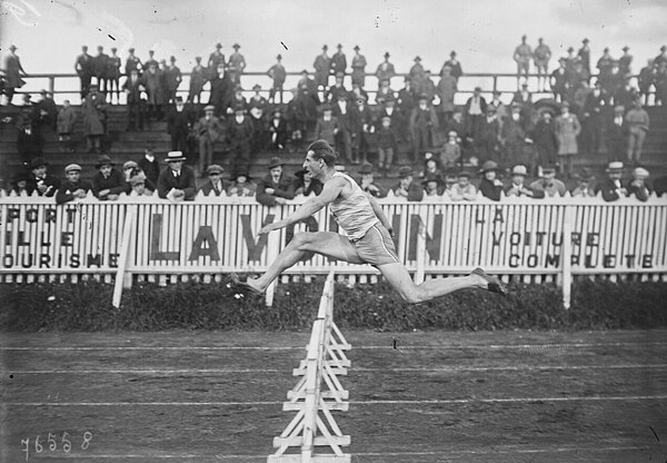 Géo André jumps over a barrier during the 400 metres hurdles in 1922