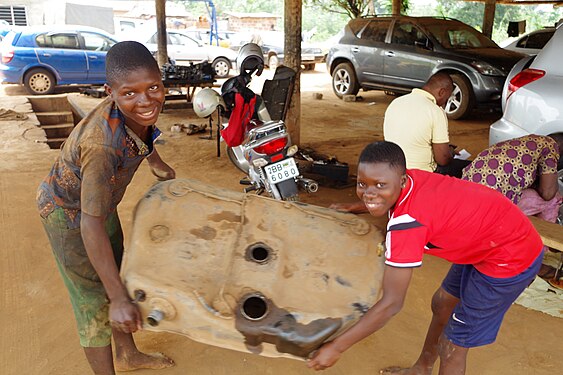 WASHING OF RESERVOIR GASOLINE OF A CAR IN A CAR GARAGE BY A GIRL AND YOUNG PEOPLE IN BENIN