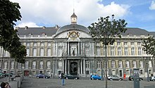 Un grand bâtiment en pierre avec une tour d'horloge sur son toit