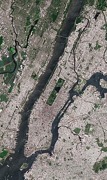 Satellite image of Manhattan Island, bounded by the Hudson River to the west, the Harlem River to the north, the East River to the east, and New York Harbor to the south, with rectangular Central Park prominently visible. Roosevelt Island, in the East River, belongs to Manhattan.