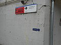 A dark orange Exit sign to the south staircase and a small braille sign.