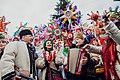 Musicians with Ukrainian folk instruments perform carols in front of the Christmas tree, among Christmas stars