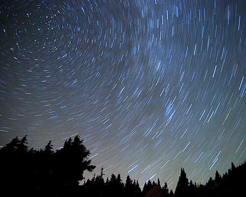 A long-exposure image of star trails in the night sky above Mount Hood National Forest, Washington, facing north at 6,600 ft (2,000 m) above sea level
