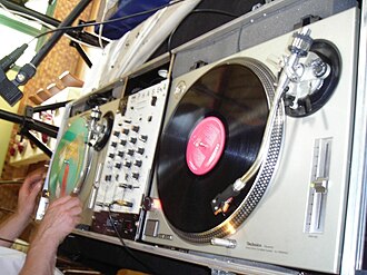 The packaging features a disc jockey motif, including imagery such as a DJ turntable like the one pictured. Platines vinyles.jpg