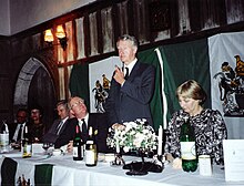 Ian Smith speaking at a dinner in England, with Rhodesian flags behind him. Smith Dinner.jpg