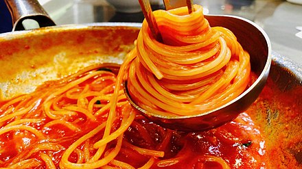 Spaghetti being prepared with tomato sauce