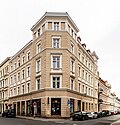 Apartment building with original shop fronts in closed development, corner house