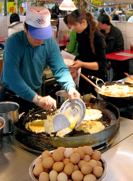 A hawker is making oyster omelets in Shilin Night Market, Shilin, Taipei, Taiwan.
