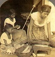 Una mujer y sus niñas haciendo tortillas en El Salvador