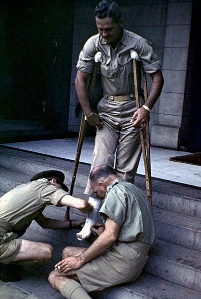 File:War correspondent Earl Crotchett on crutches on the steps of a hotel in Townsville, 1942 (5098865852).jpg