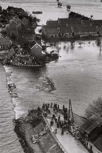 A breach in a levee in Papendrecht, the Netherlands, during the North Sea flood of 1953, flooding houses that had been built behind it