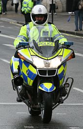 Front view of a yellow BMW R1200RT with "Police" signage, police rider and emergency lighting