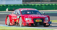 Voiture de marque Audi rouge, vue de trois-quarts, dans son ensemble.