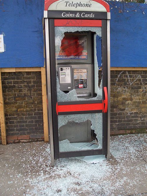 A vandalised telephone booth made with tempered glass