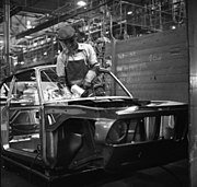 Een medewerker van BMW slijpt het dashboard. 1968