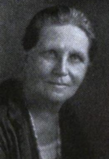 Middle-aged white woman with hair brushed back from forehead