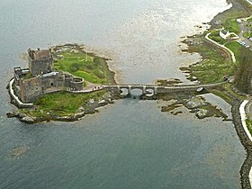 Vue aérienne d'Eilean Donan, de son château et de son pont baignés par les eaux du loch Duich.