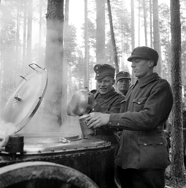 Finnish soldiers gather breakfast from a field kitchen during "additional refresher training" at the Karelian Isthmus, on 10 October 1939.