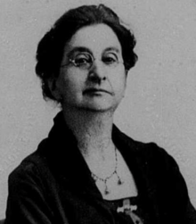 Photograph of a white woman wearing glasses